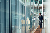 Man in modern building using cell phone