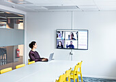 Woman having video conference in boardroom