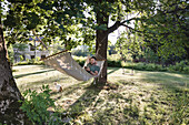 Man lying in hammock in garden