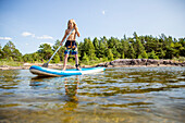 Smiling boy paddleboarding