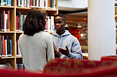 Two students talking in library