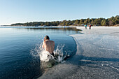 Mann springt in eiskaltes Wasser