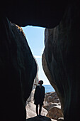 Man standing in cave at seaside