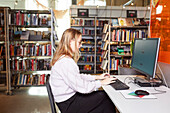 Studentin benutzt Computer in der Bibliothek
