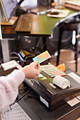 Frau beim Bezahlen mit Kreditkarte