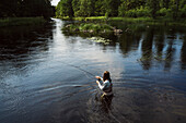 Woman fishing in river