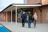 Friends walking towards school entrance