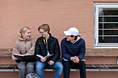 School friends sitting on bench and studying