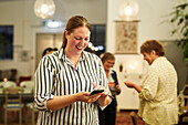Frau mit Smartphone während eines Treffens im Cafe