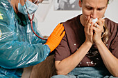 Doctor with stethoscope examining patient at home