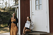 Young female friends in front of house