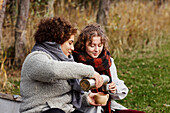Female friends drinking from insulated drink container