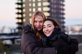 Portrait of smiling female couple against apartment block