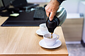 Man pouring coffee into cup