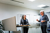 Colleagues talking in office kitchen