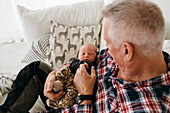 Grandfather holding newborn baby grandson