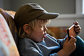 Boy in baseball cap using smart phone