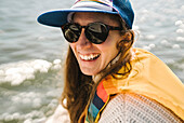 Portrait of smiling woman in sunglasses against sea