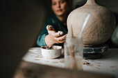 Young woman making clay vase