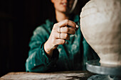 Female potter making clay vase