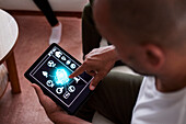 Mann nutzt Smart-Home-Anwendung auf dem Tablet