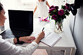 Woman in kitchen using laptop