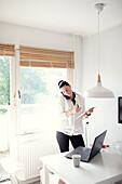 Woman in kitchen using cell phone