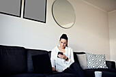 Woman on sofa using cell phone