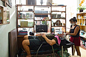 Älterer Mann lässt sich im Friseursalon die Haare waschen