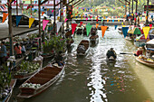 People in boats shopping at farmer's market along canal