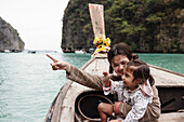 Mutter und Tochter sitzen in einem traditionellen Boot in einer Schlucht
