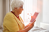 Ältere Frau mit digitalem Tablet
