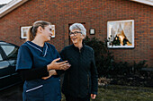 Home caretaker going on walk with senior woman