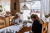 Grandmother and adult granddaughter eating at home