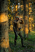 Jäger im Wald schaut durch ein Fernglas