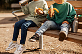 Kinder beim Essen auf dem Spielplatz
