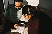 Father and mother with baby on sofa