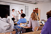 Teenager writing on whiteboard in classroom