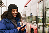 Frau telefoniert an der Bushaltestelle