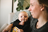 Smiling mother holding newborn baby