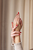 Nahaufnahme von Frauenhänden mit rotem Nagellack