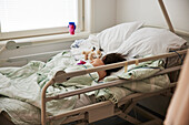 Kind schläft im Krankenhausbett