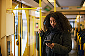 Frau im Bus benutzt Mobiltelefon