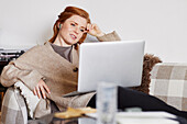 Woman on sofa using laptop