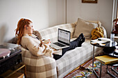 Woman on sofa using laptop