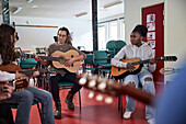 Teenagers attending guitar lesson