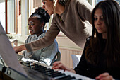 Teenage girls and teacher during keyboard lesson