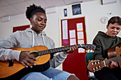 Teenagers attending guitar lesson