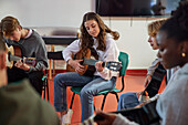 Teenager beim Gitarrenunterricht