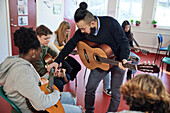 Teenagers attending guitar lesson